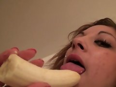 Beauty sucks on a banana while naked